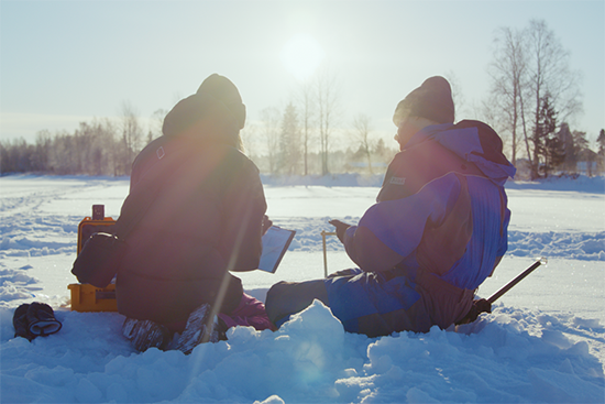 Lumitutkijoita talvimaisemassa.