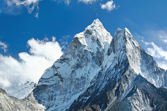 Summit of Mt. Ama Dablam in front of a blue sky.