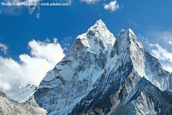 Summit of Mt. Ama Dablam in front of a blue sky.