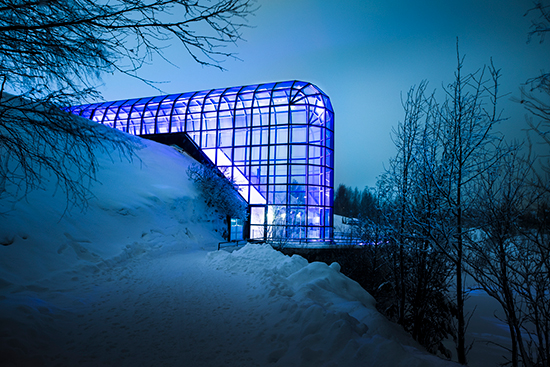 Arktikum-talon lasiputki sinisessä juhlavalaistuksessa.